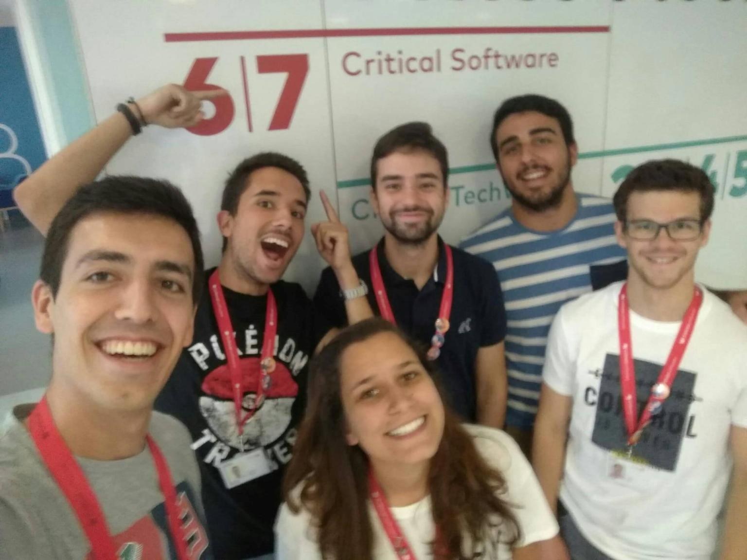 Rafael Correia and fellow interns in front of the Critical Software sign