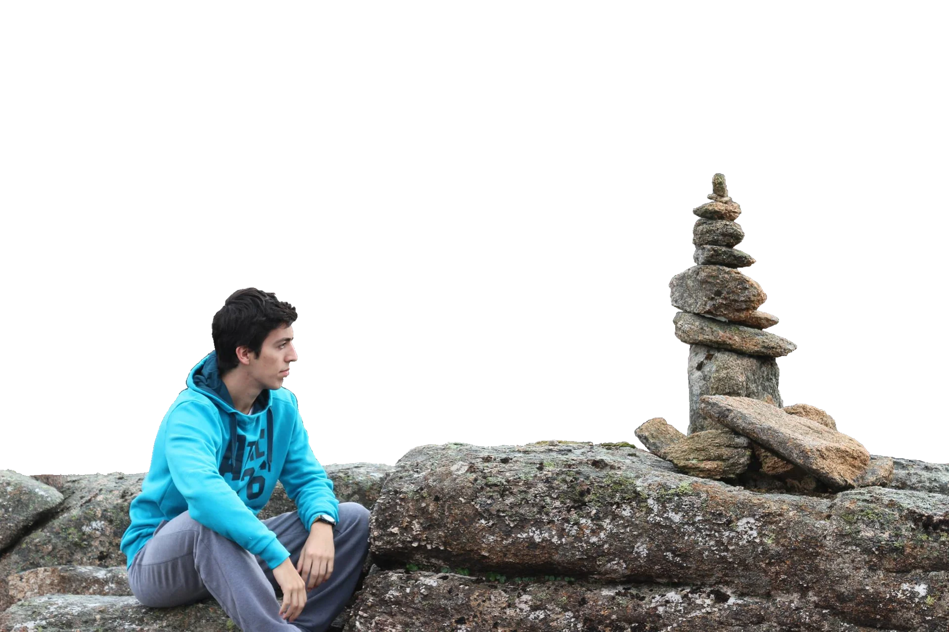 Rafael Correia sitting on rocks beside a stone cairn